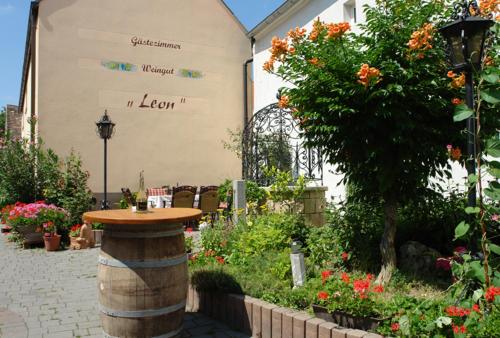 einen Garten mit einem Tisch in einem Fass vor einem Gebäude in der Unterkunft Winzerzimmer - Weingut Tinhof in Eisenstadt