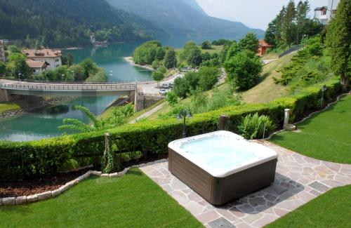 een ligbad in het gras naast een rivier bij Charme Hotel Nevada in Molveno