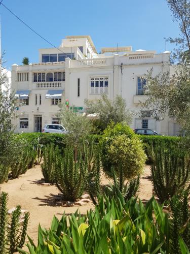 a building with a lot of plants in front of it at Maison d'Hôtes Dar Ennassim in La Marsa