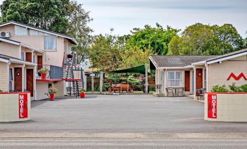 um parque de estacionamento em frente a duas casas em Tourist Court Motel em Whakatane