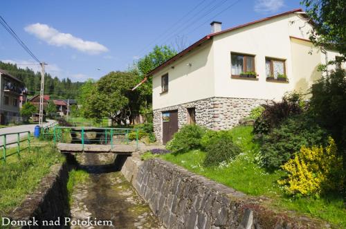 uma casa e uma ponte sobre um rio em Domek nad potokiem em Kluszkowce