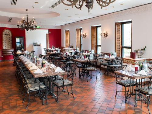 a restaurant with tables and chairs in a room at DORMERO Hotel Stuttgart in Stuttgart