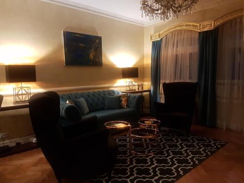 sala de estar con sofá azul y sillas en GoldStar Luxury Old Town Krakow Apartment, en Cracovia