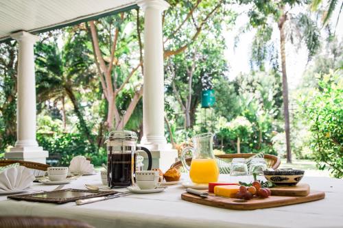 una mesa con comida y una jarra de zumo de naranja en York Lodge, en Harare