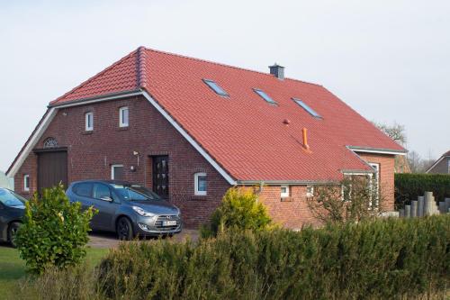 a house with a car parked in front of it at Gästehaus Marichen in Aurich