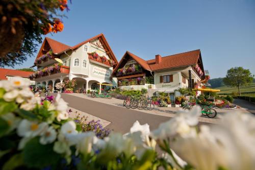 a couple of buildings with flowers in front of them at Pension Drei-Mäderl-Haus in Unterlamm