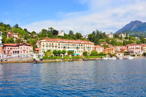 un gruppo di edifici sulla riva di un corpo idrico di Grand Hotel Menaggio a Menaggio