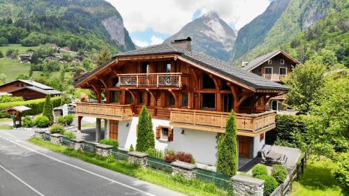 une grande maison en bois sur le côté d'une route dans l'établissement Chalet Clos Moccand, à Samoëns