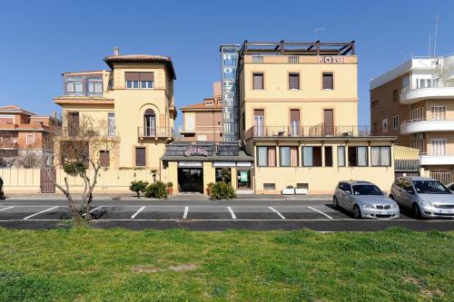 dwa samochody zaparkowane na parkingu przed budynkiem w obiekcie Hotel Bellavista w mieście Lido di Ostia