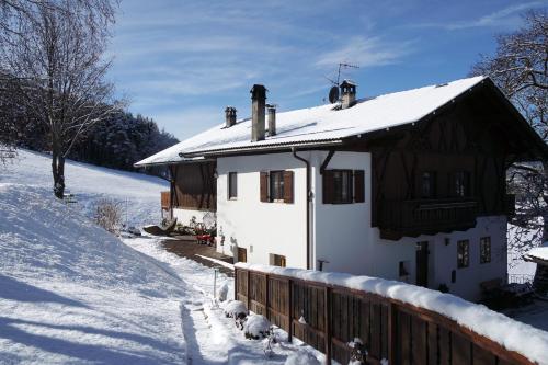 een huis bedekt met sneeuw met een houten hek bij Gemangerhof in Bressanone