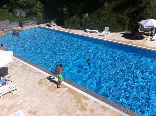 un groupe de personnes dans une grande piscine dans l'établissement Hotel Apartamentos Geres Ribeiro, à Gerês