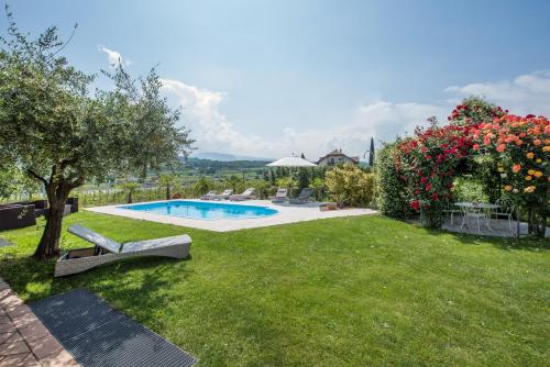 um jardim com piscina e algumas flores em Villa Raifer em Appiano sulla Strada del Vino