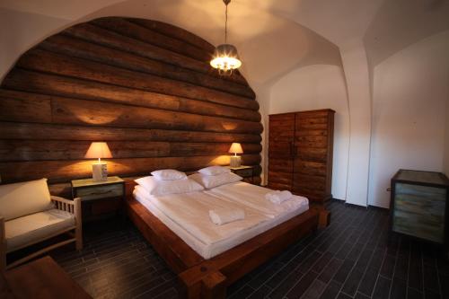 een slaapkamer met een groot bed en een houten muur bij Régi Posta Étterem és Fogadó in Debrecen