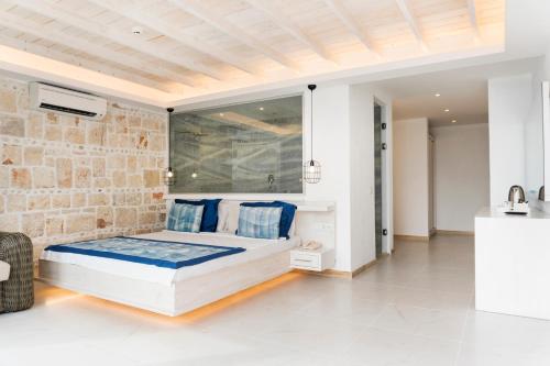 - une chambre avec un lit et un mur en briques dans l'établissement Nur Beach Hotel, à Kaş