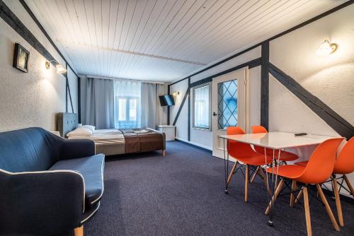 a hotel room with a bed and a table and chairs at Great Polonia Jelenia Góra City Center in Jelenia Góra