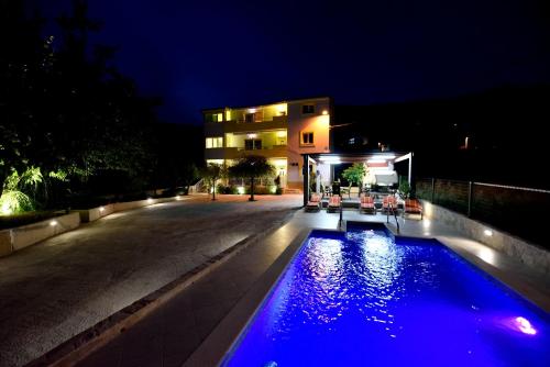 - une piscine en face d'un bâtiment la nuit dans l'établissement Over the skyline, à Podstrana