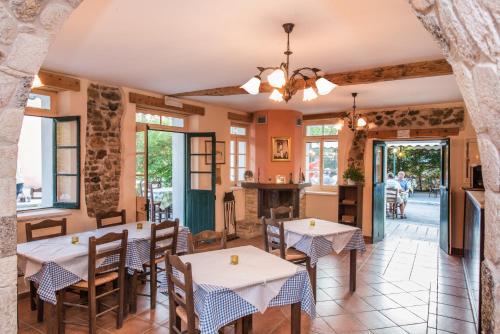 a restaurant with tables and chairs in a room at Takis Family Corfu in Kontokali