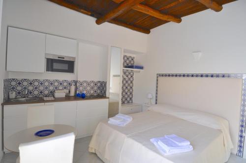 Il comprend une chambre blanche avec un lit et une cuisine. dans l'établissement Stella Marina Amalfi Dreams, à Ravello