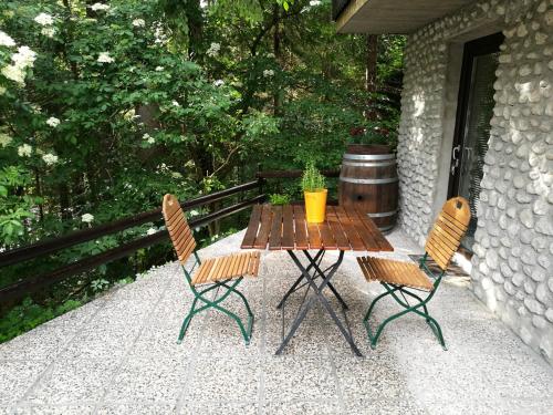 een houten tafel en 2 stoelen op een patio bij Apartments Jelka in Kranjska Gora