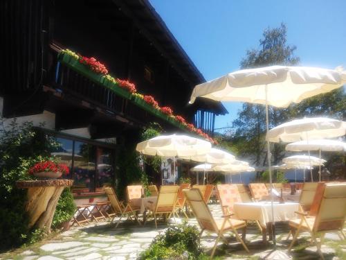 eine Gruppe von Stühlen und Sonnenschirmen auf einer Terrasse in der Unterkunft Berghotel Blaickner's Sonnalm in Zell am See