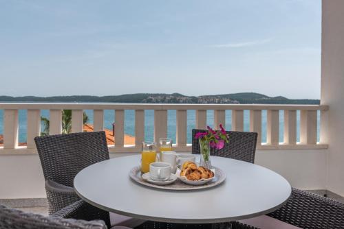 - une table avec une assiette de petit-déjeuner sur un balcon dans l'établissement Villa Ana Trogir, à Trogir