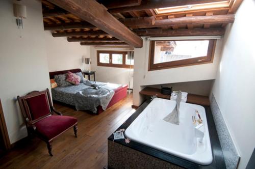 a living room with a bath tub and a bedroom at L'Argolla Hotel-Pizzeria in Santa Coloma de Farners