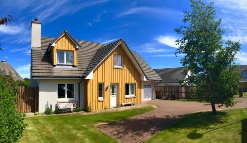 een huis met een geel en grijs dak bij Hector's House in Aviemore