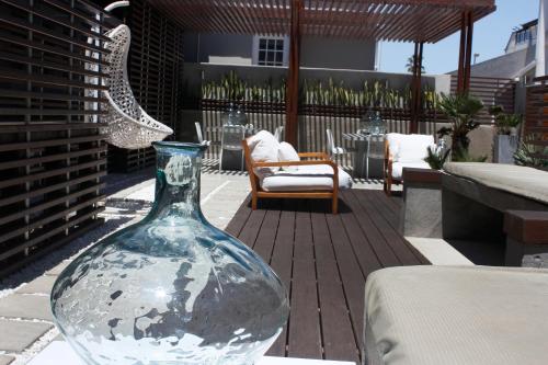 un vase en verre assis sur une table sur une terrasse dans l'établissement Swakopmund Luxury Suites, à Swakopmund