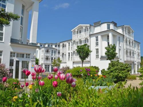 einen Garten vor einem weißen Gebäude mit Blumen in der Unterkunft Seepark Sellin - Apt. 382 in Ostseebad Sellin