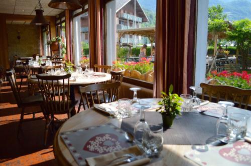 un ristorante con tavoli e sedie e una grande finestra di Auberge de Costaroche ad Albertville