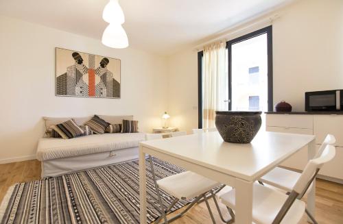 uma sala de estar branca com uma mesa e cadeiras brancas em Balaguer House em Alghero