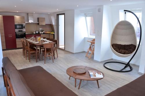 uma sala de estar e cozinha com uma mesa e um espelho em Les Suites Du Cygne em Colmar