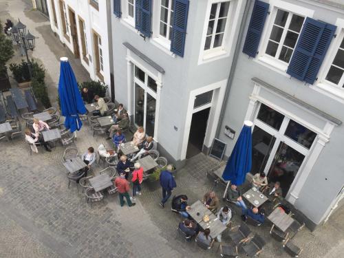 grupa ludzi siedzących przy stołach przed budynkiem w obiekcie Ferienwohnungen Rheine Markt 12 w mieście Rheine