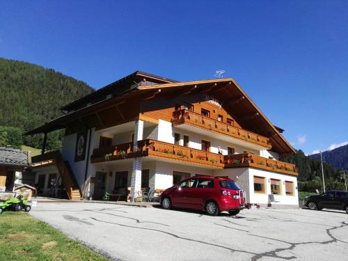 un edificio con una macchina rossa parcheggiata di fronte di Pension Wiesenhof a Campo di Trens