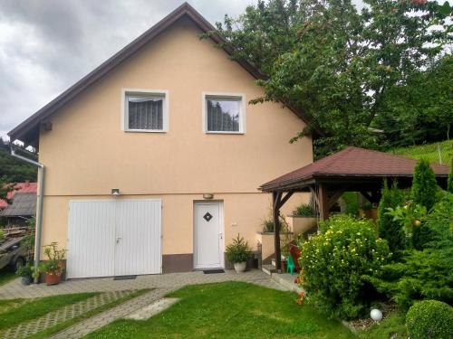 a house with a white door and a yard at Apartmán 80 in Oravský Podzámok