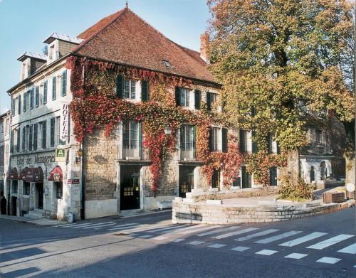 ein altes Gebäude an der Straßenseite in der Unterkunft Logis Hôtel des Messageries in Arbois