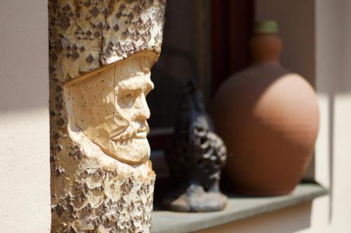 a shelf with a statue of a head and pottery at Leo Vendeghaz in Eger