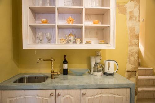 a kitchen counter with a sink and a bottle of wine at Cretan Renaissance in Chania Town