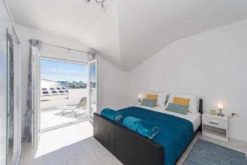 um quarto com uma cama grande e uma varanda em Apartments HIPERION em Zadar