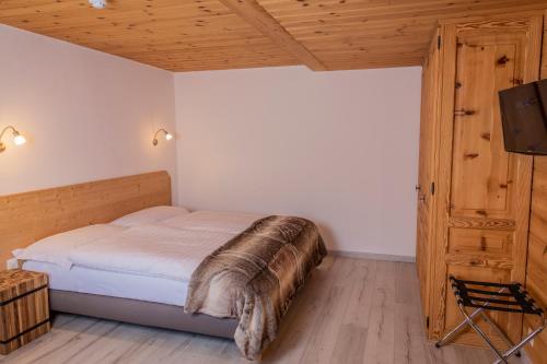 Una cama o camas en una habitación de Hôtel Alpina - Swiss Ski & Bike Lodge Grimentz