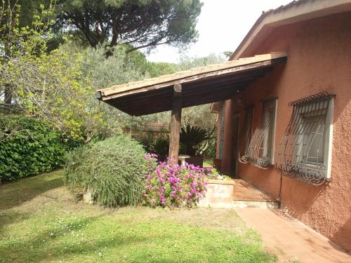 un portico di una casa con un mazzo di fiori di villetta nel verde vicino spiaggia a Orbetello