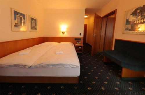 a hotel room with a large bed and a couch at Karaman Group Hotel in Bad Nenndorf