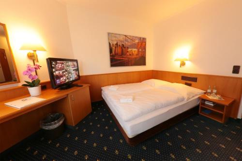 a hotel room with a bed and a television at Karaman Group Hotel in Bad Nenndorf