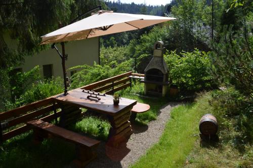 un tavolo da picnic e un ombrellone in giardino di Luzik Krynica a Krynica-Zdrój