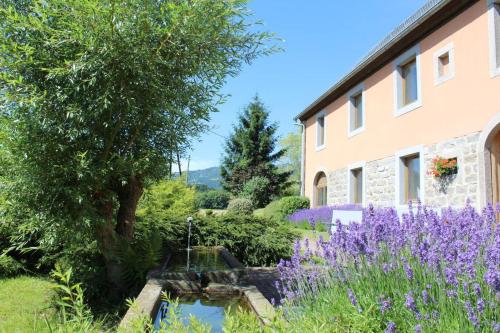 un jardín con flores púrpuras junto a un edificio en Gîte Les 4 Saisons, en Orbey