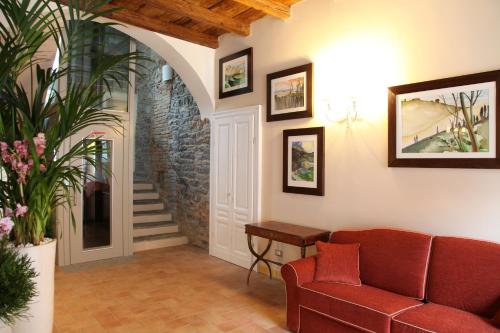 a living room with a red couch and a staircase at Hotel Borgo Antico in Como