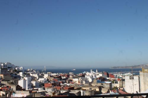 una ciudad con edificios blancos y el océano en el fondo en Riad Tingis, en Tánger