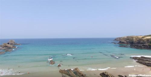 uma vista para uma praia com pessoas na água em SigmaApartment na Zambujeira do Mar