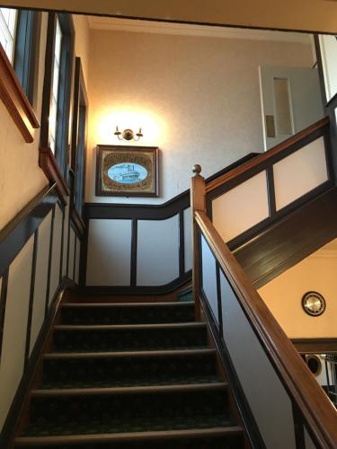 un escalier dans un bâtiment avec une horloge sur le mur dans l'établissement The Kamo Hotel, à Whangarei