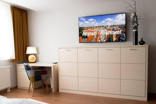 a bedroom with a tv on top of a dresser at Altstadt-Apartment in Freiberg